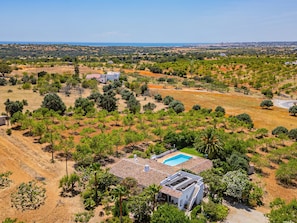 A house with a swimming pool, surrounded by trees and a hilly landscape. - Villa Alice (Albufeira)