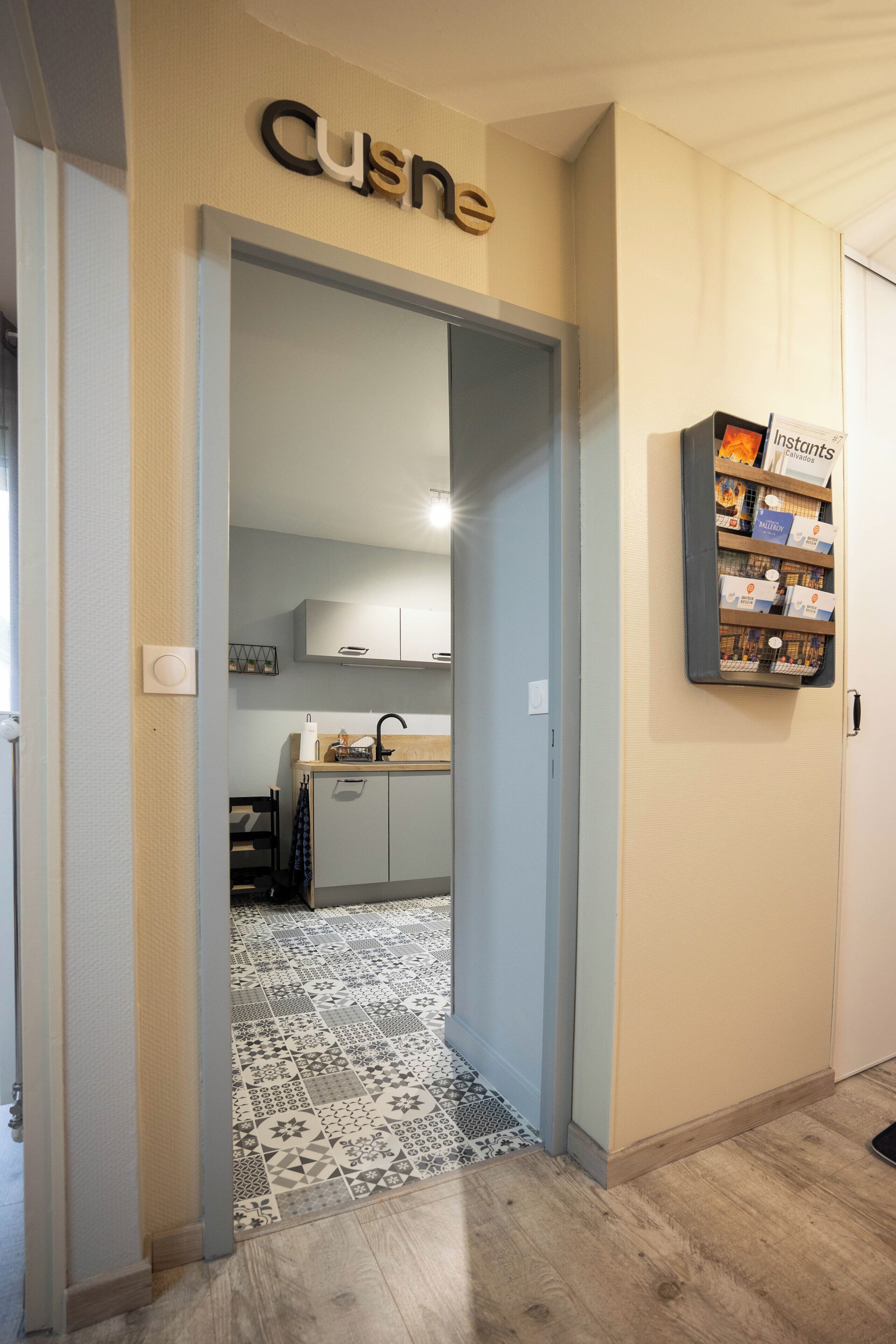 A hallway leading to a kitchen with a 'Cuisine' sign above the door.
