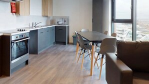 A modern kitchen with a dining area, large windows, and a sofa. - For Students Only Canvas Arundel House in Coventry (Coventry)