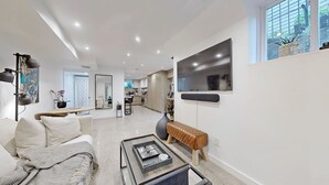 Un salon moderne avec un canapé, une table basse et un téléviseur fixé au mur.