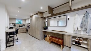 Une cuisine moderne avec des meubles en bois, un grand miroir et un banc.