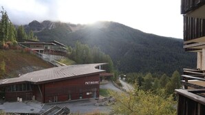 A modern building with a sloped roof and a sign reading "PATINOIRE" in front. - Resort center, 3rd floor, balcony, tv, ski locker, 28m², Les Orres (Les Orres)