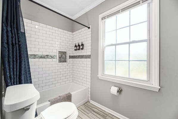 Un baño con bañera, inodoro y zona de ducha.