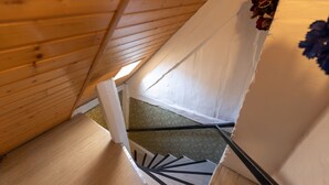 Een houten trap met witte muren en een tapijt met een groen patroon.