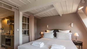 A hotel room with a large bed, two bedside tables with lamps, a wardrobe, and a bathroom visible through an open door. - Dolphin View - 2nd floor - Beautiful flat with view of the port (Honfleur)