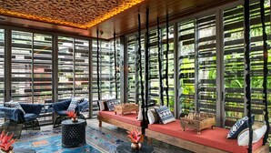 A modern lounge area with seating, a chessboard, and a patterned rug.