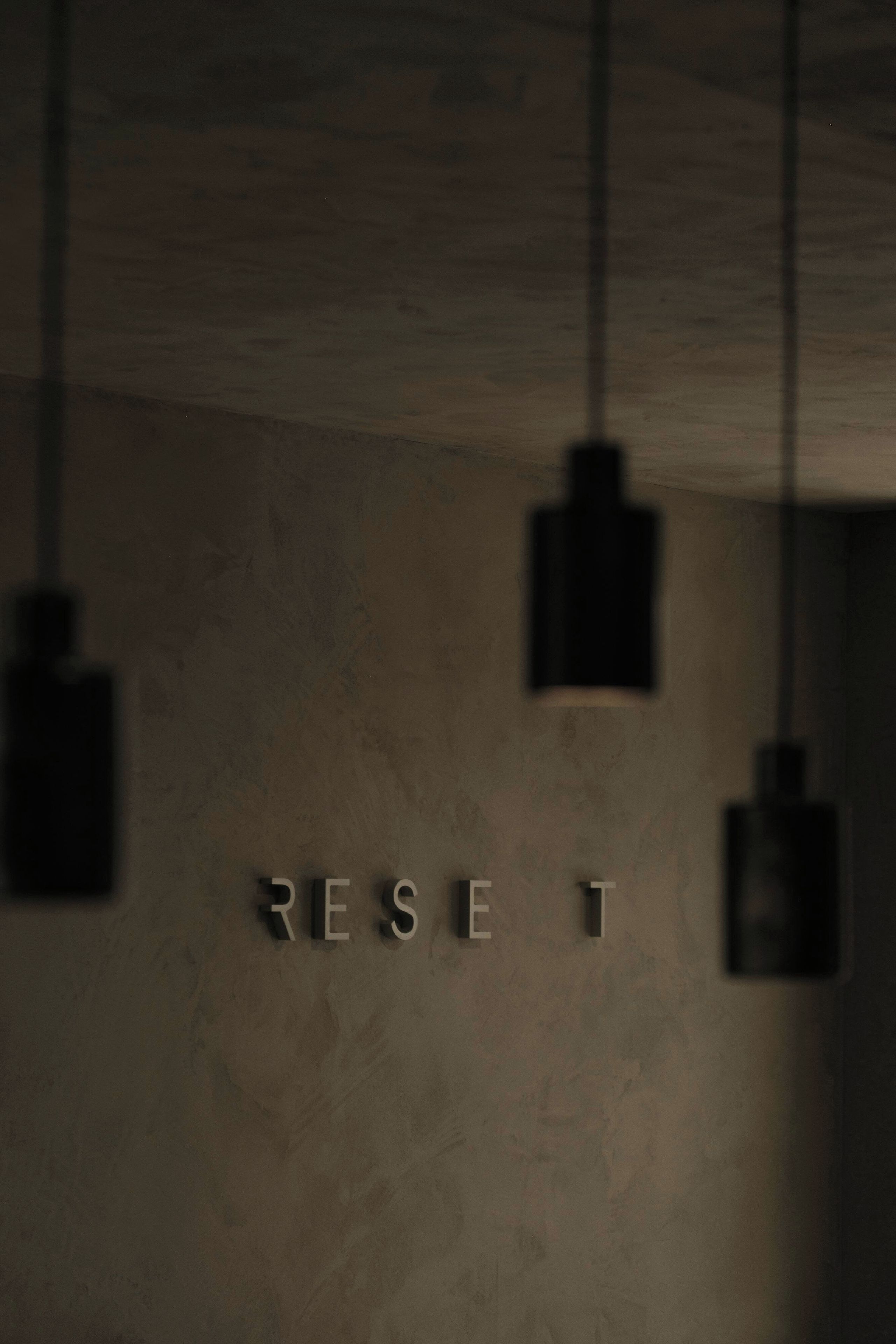A room with a textured wall and hanging light fixtures.