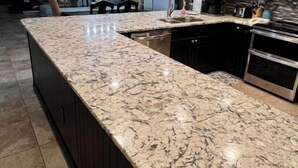A modern kitchen with a large island, dark cabinetry, stainless steel appliances, and a tiled floor. - Beachfront Oasis! 2BR,2BA with Private Beach Access and free upfront parking.  (Destin)