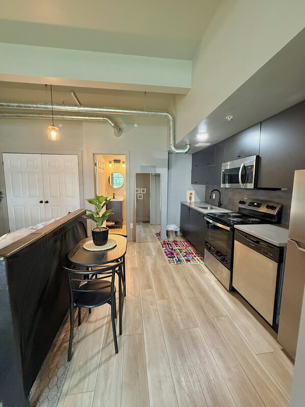 Una cocina moderna con comedor, microondas, estufa y refrigerador.