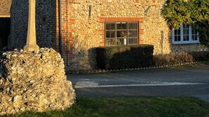Ein Steinhaus mit Ziegeldach, Schornstein und Satellitenschüssel.