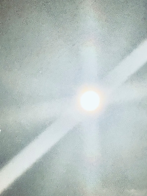 A ceiling with a light fixture and a shadow pattern.