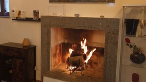 A fireplace with a painting above it, a shelf with items, and a tiled floor. - Location Le 10&10 idromassaggio in camera Nepi VT (Nepi)