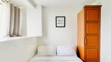 Tabla de planchar con plancha y ropa de cama