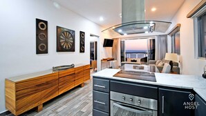Una cocina moderna con una isla central, armarios de madera y vistas al exterior.