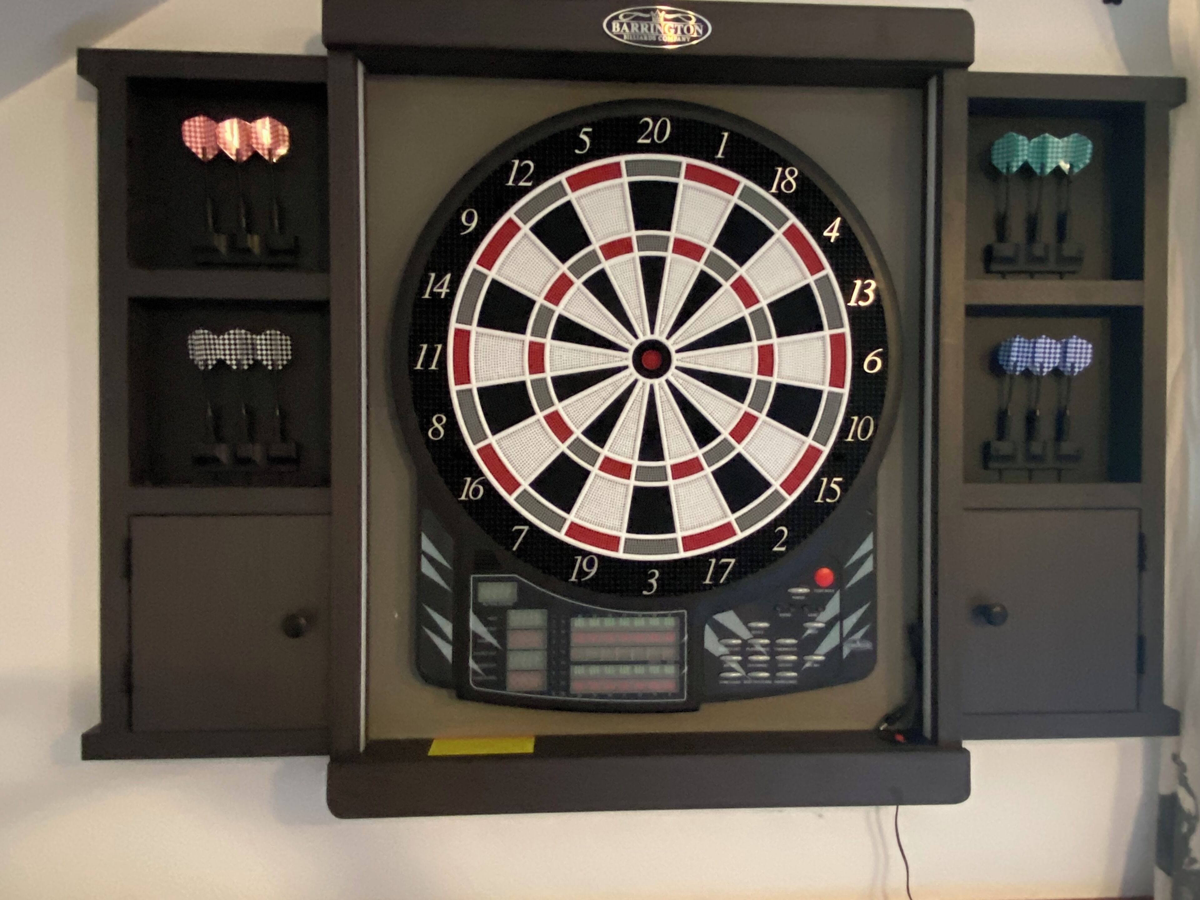 Dartbord aan een muur bevestigd, met een scorebord eronder.