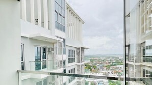Un appartement moderne doté d’un balcon, de grandes fenêtres et offrant une vue sur la ville.