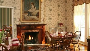 Comedor con chimenea, candelabro y un cuadro sobre la repisa.