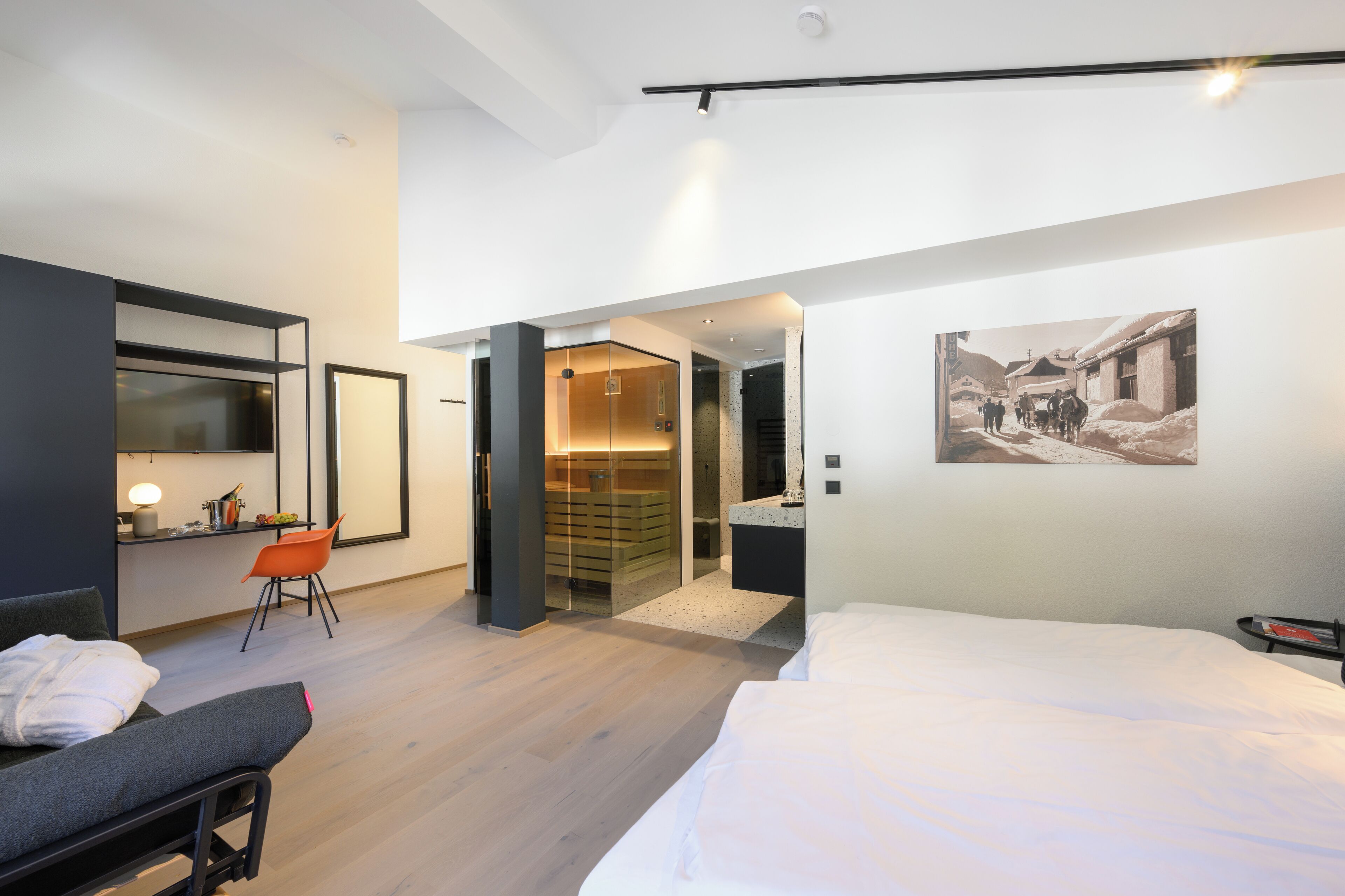 Ein modernes Hotelzimmer mit Bett, Schreibtisch mit Stuhl, Kleiderschrank und Bad.