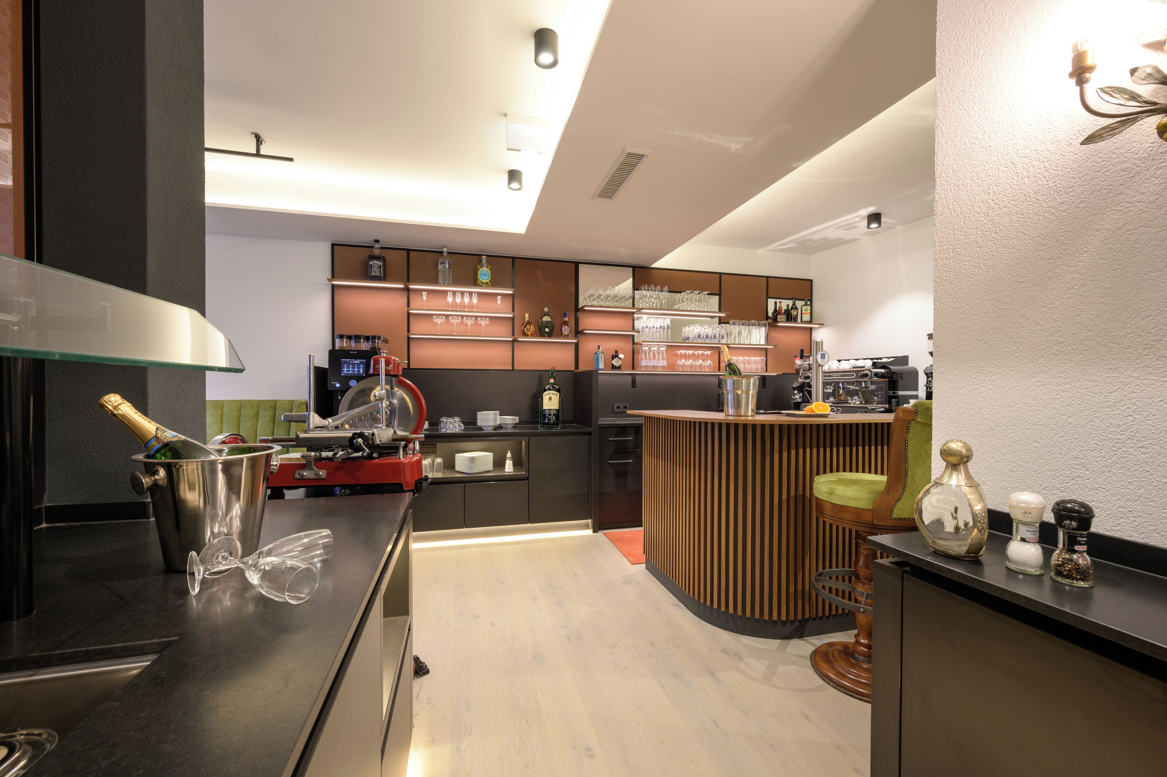 Une cuisine moderne dotée d’un coin bar, avec un verre à vin, une bouteille de champagne et divers appareils de cuisine.