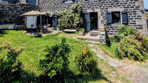 A stone building with a patio, a barbecue grill, and a garden. - A large 250m2 farmhouse with authentic, rustic charm, Le Repaire (Mazet-Saint-Voy)