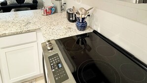 A kitchen with a built-in microwave, a stove, and a coffee maker. - Charming Cottage “Yellow Haus” near Gruene (New Braunfels)