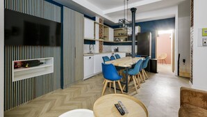 A modern kitchen with a dining area, a TV mounted on the wall, and a fireplace. - TBS 51 - Spacious and modern duplex apartment (Paris)