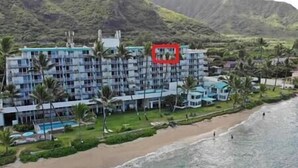 A beachfront hotel with multiple balconies, a pool, and a view of the ocean.