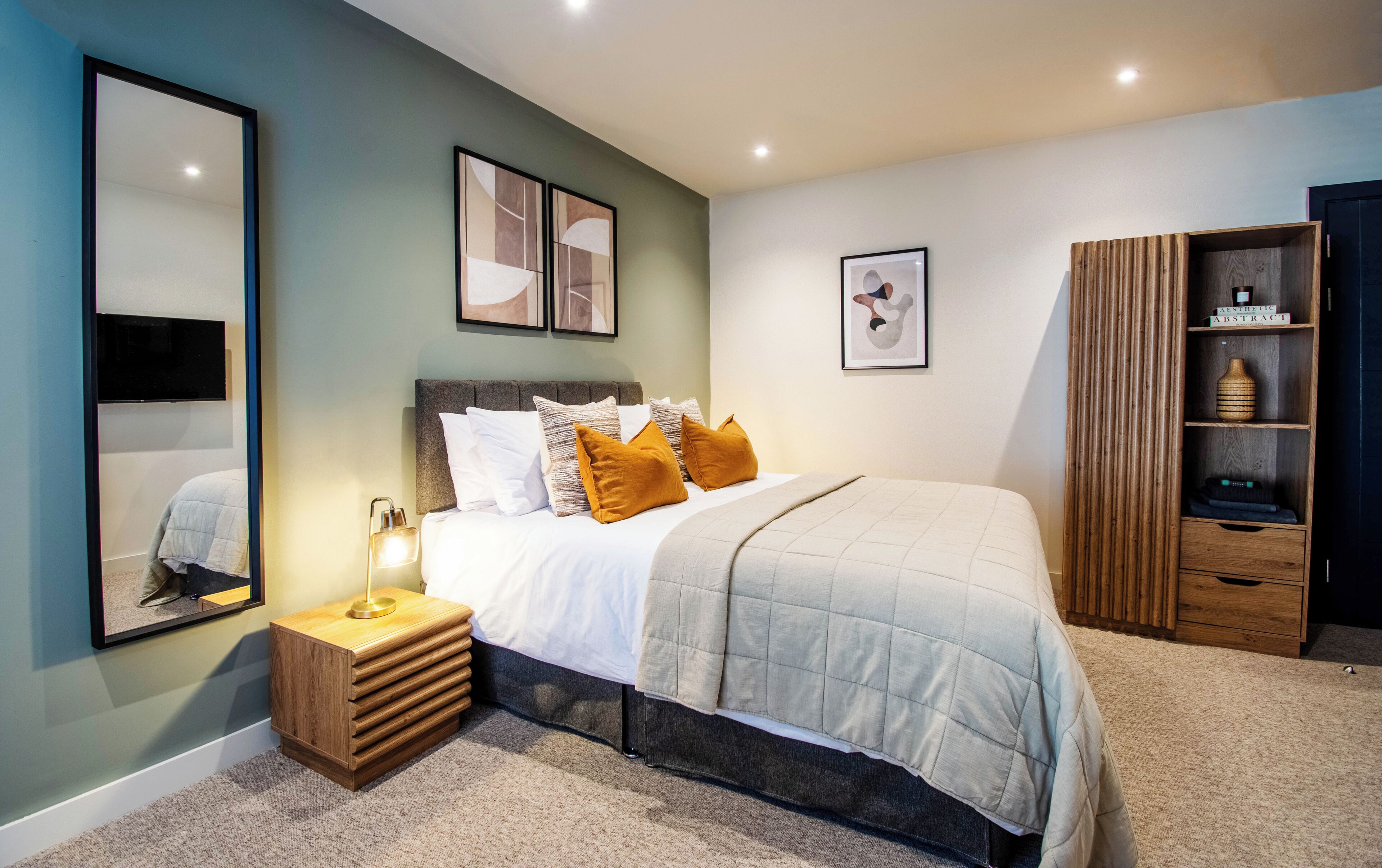 Une chambre à coucher moderne avec un lit, une table de chevet et une armoire en bois.