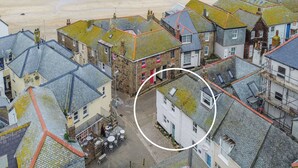 A coastal town with stone buildings, a beach in the background, and a circled building with a visible window. - 2 bedroom accommodation in St Ives (St Ives)