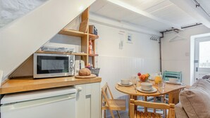 A compact kitchen with a microwave, toaster, and a bread loaf on the counter. - 2 bedroom accommodation in St Ives (St Ives)