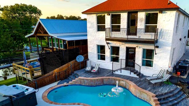 A house with a swimming pool, a covered deck, and a two-story balcony. - Lakefront Home w/ Pool, Spa, & Game Room! (Kingsland)