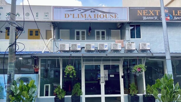 Un edificio con un letrero que dice 'D'Lima House' y 'Next Level Barber'.