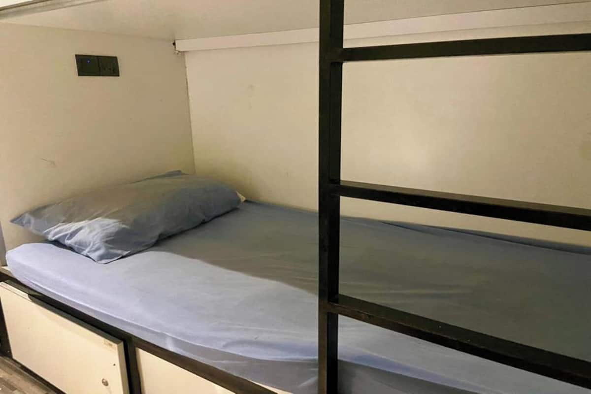 A bunk bed with a single mattress and a pillow.