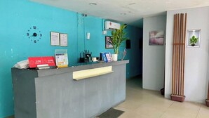 Una recepción con un reloj, un calendario y una planta.