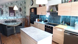 A modern kitchen with a central island, built-in oven, and a dishwasher.