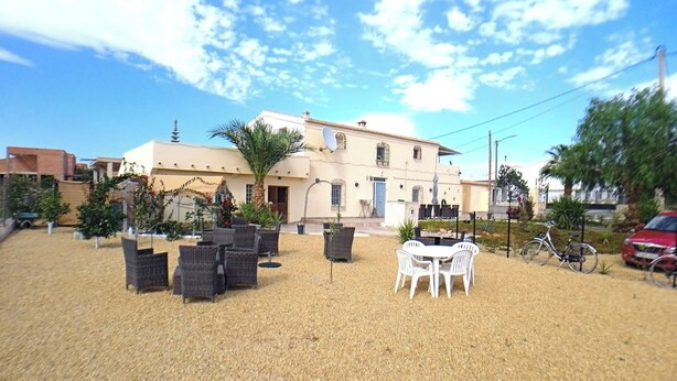 A building with a patio area featuring wicker furniture and a white table.
