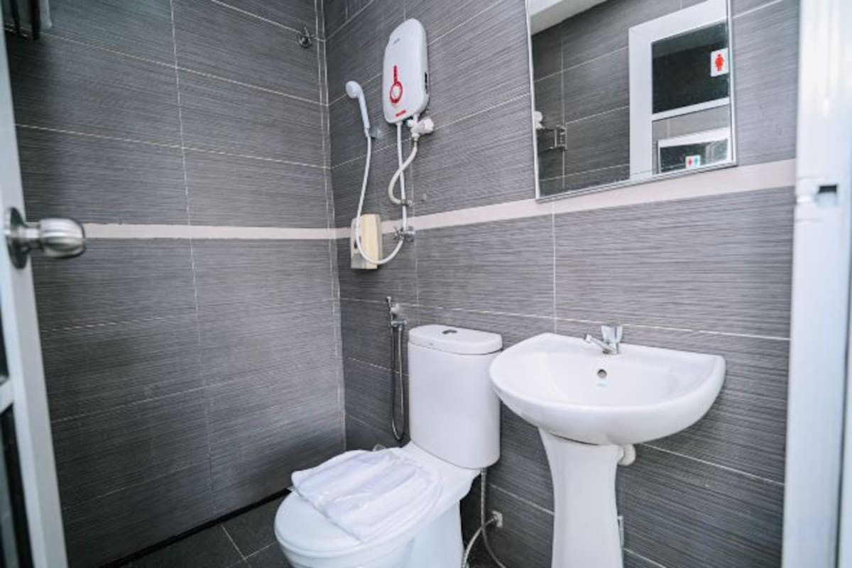 A bathroom with a toilet, bidet, and sink, all in white.