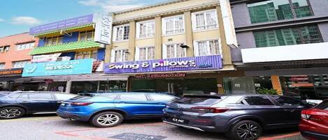 A street view with a building featuring a sign for 'Swing & Pillows' and another for 'MEDESA.'