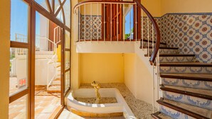 A spacious balcony with a view of the sea, a wooden staircase with patterned tiles, and a small fountain. - Cubo's Casa La Paloma / family / free Wi-Fi / private heated pool (Marbella)