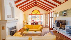 A spacious living room with a fireplace, yellow sofa, and a television. - Cubo's Casa La Paloma / family / free Wi-Fi / private heated pool (Marbella)