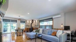 A modern living room with a sofa, a coffee table, and a fireplace.