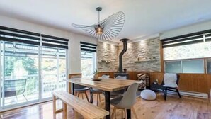 A modern dining area with a wooden table, benches, and a unique ceiling fan.