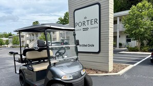 Een golfkarretje geparkeerd voor een gebouw met een bord waarop staat: The Porter Avenue Condos 114 Ethel Circle.
