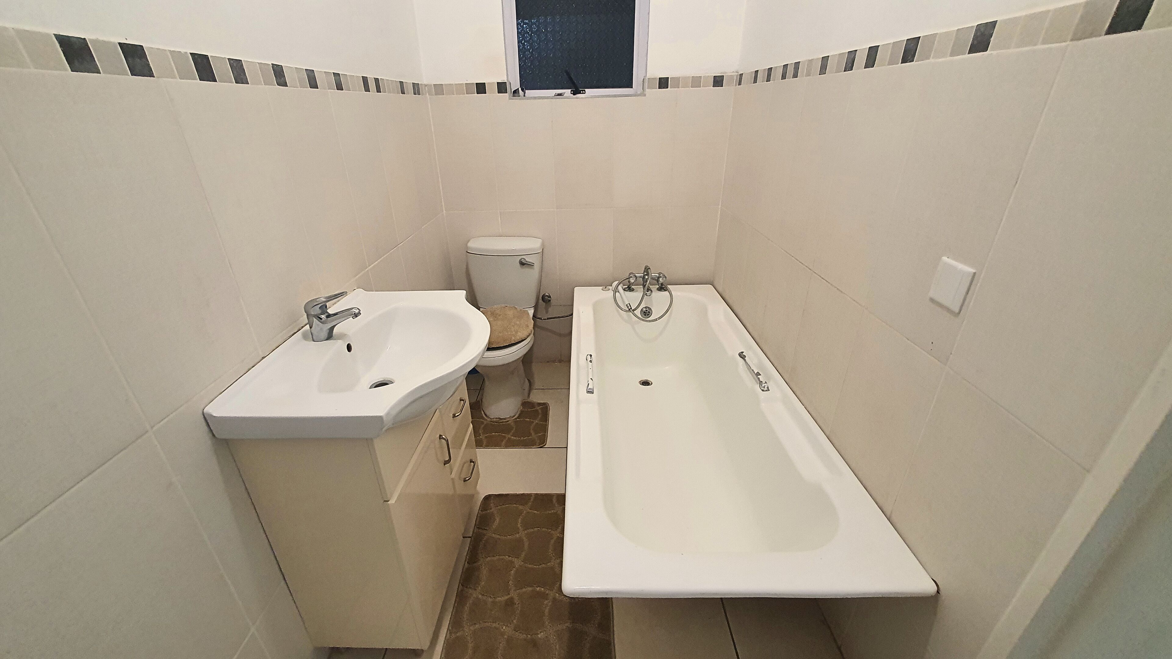A small bathroom with a sink, toilet, and bathtub.