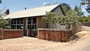 A building with a brick facade, large windows, and a paved driveway.