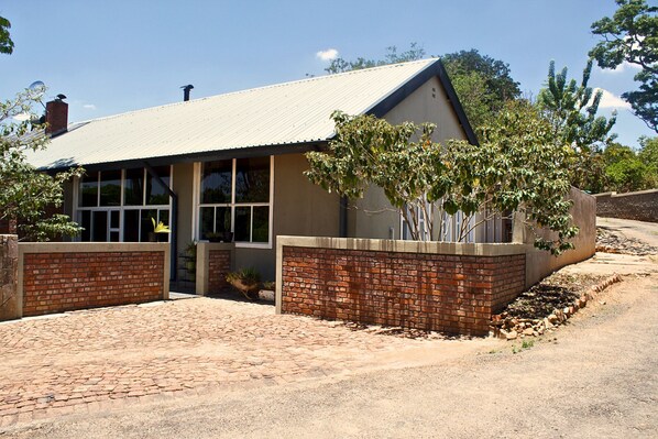 A building with a brick facade, large windows, and a paved driveway.