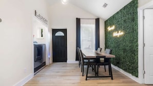 A modern kitchen with a built-in oven and a dining area with a wooden table and chairs.