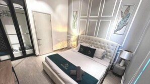 A modern bedroom with a large bed, a bedside table, a lamp, and a wardrobe.