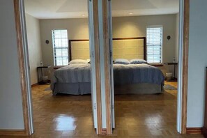 Relax in this serene bedroom with a large bed, comfortable headboard, and ample natural light.
