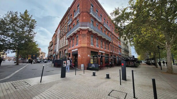A corner building with a McDonald's restaurant on the ground floor.